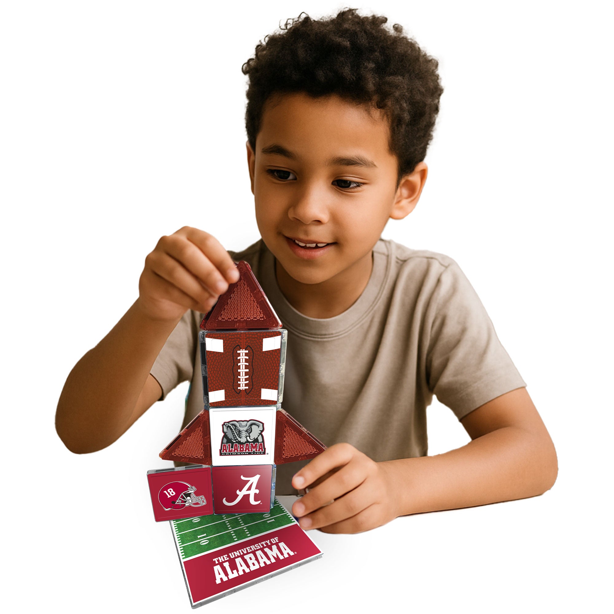 Child playing with a football-themed puzzle, featuring the University of Alabama logo.