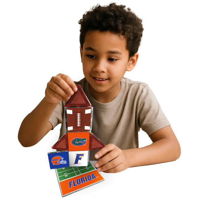 Child playing with a toy football-themed building set on a white background