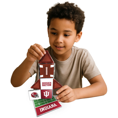 Child holding a small building model with Indiana University branding on a white background
