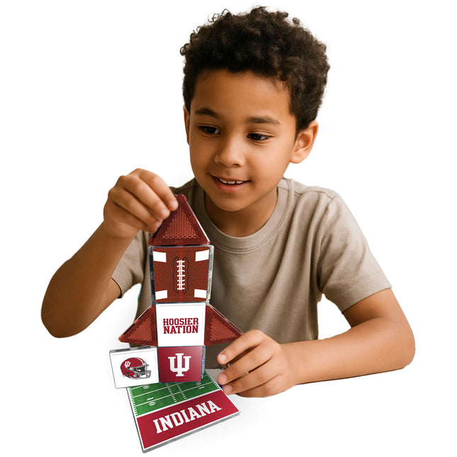 Child holding a small building model with Indiana University branding on a white background