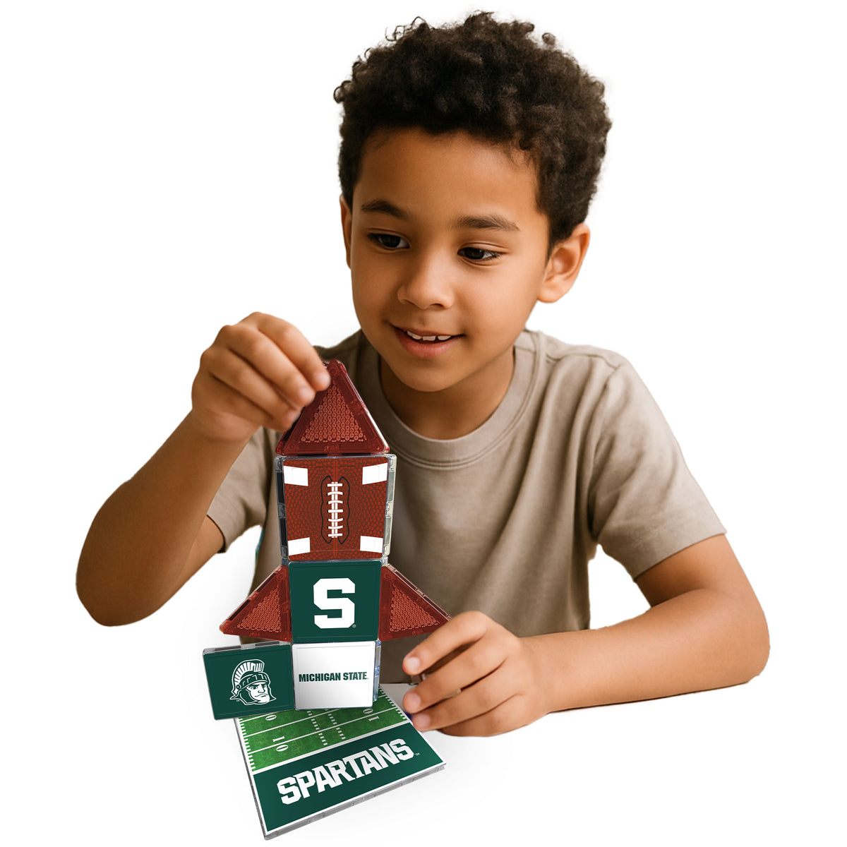 Child playing with a Michigan State Spartans-themed toy on a white background