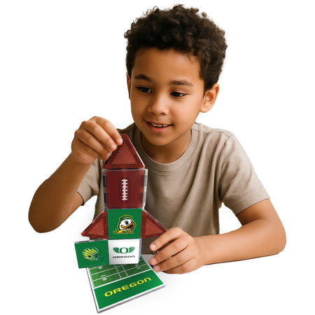 Child playing with a football-themed building set on a white background