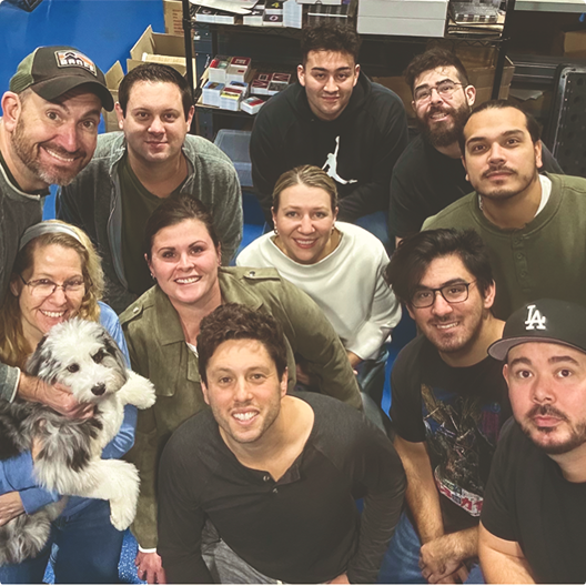 Employees of CreateOn posing together with a dog in an indoor setting.