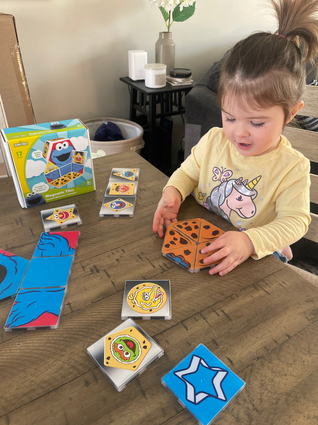 Child playing with colorful card games on a wooden table