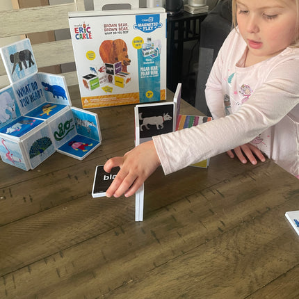 Child playing with educational cards on a wooden floor