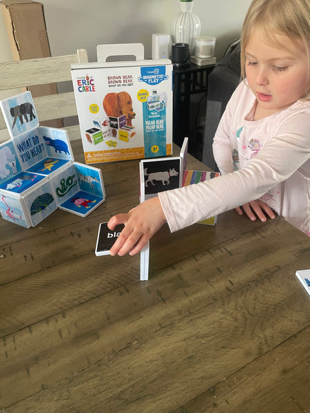 Child playing with educational cards on a wooden floor