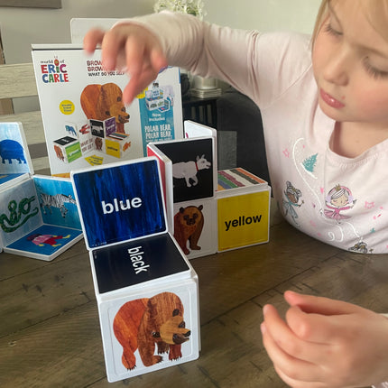Child playing with educational cards on a wooden floor