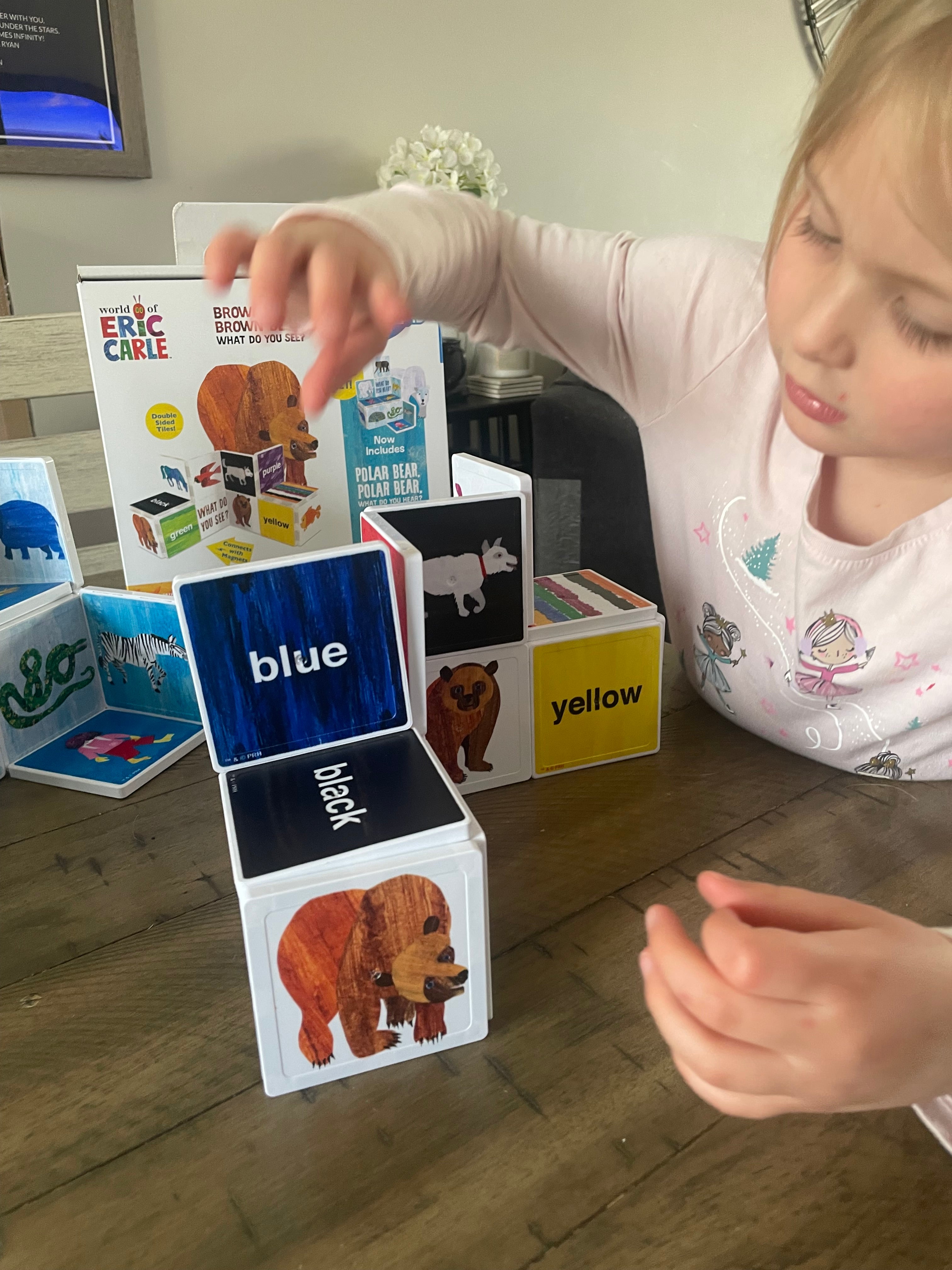 Child playing with educational cards on a wooden floor