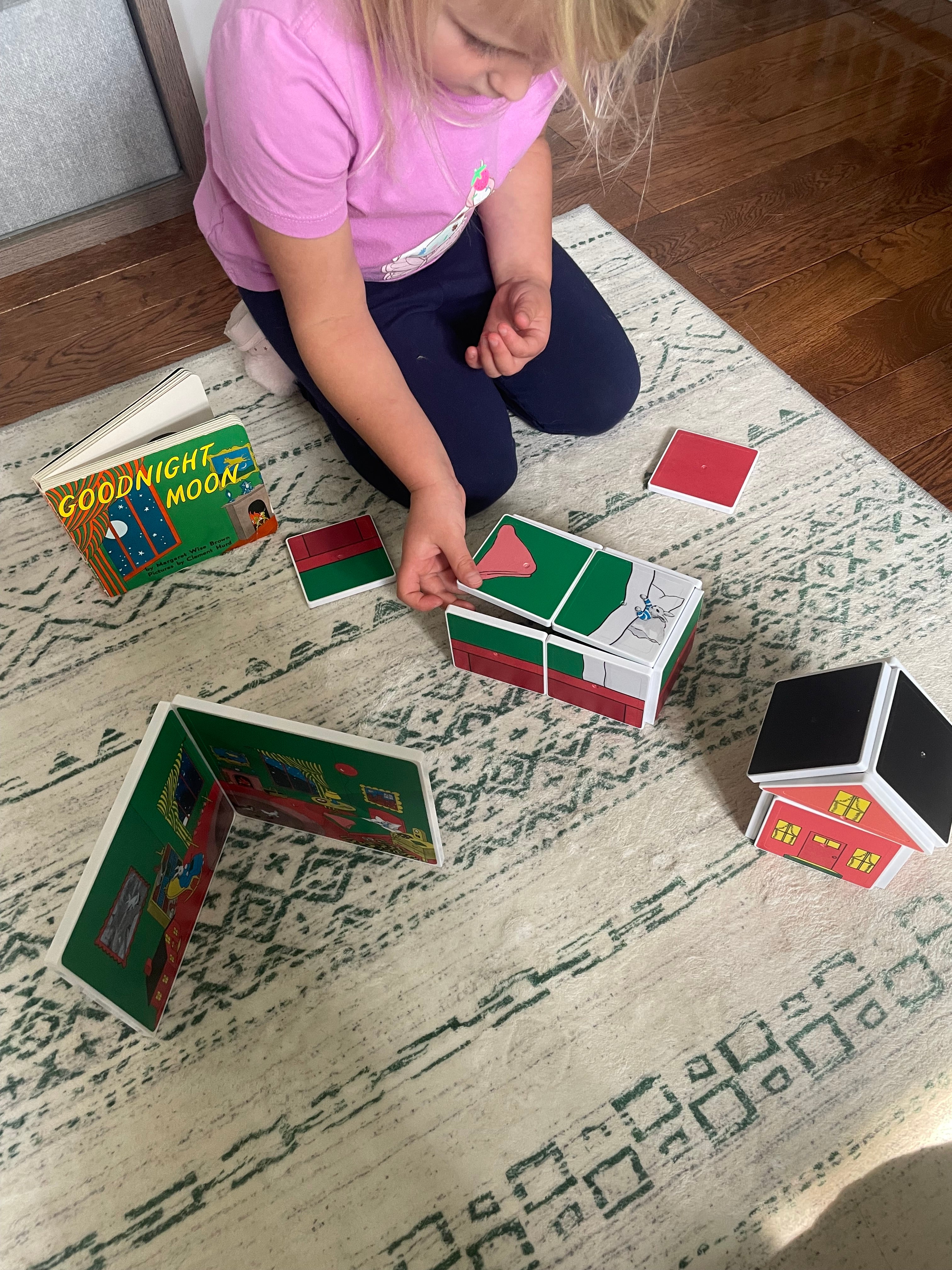Child playing with colorful cards on a patterned rug
