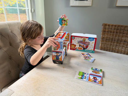 Child playing with a card game at a table in a home setting