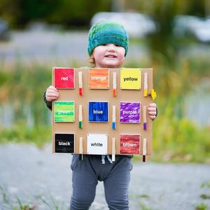 Child Holding Up Magna Tiles with Colors on Them
